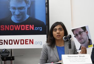 File - Naureen Shah, director of Amnesty International USA's Security & Human Rights Program, holds up a photo of Edward Snowden during a news conference to call upon President Barack Obama to pardon Snowden before he leaves office, Wednesday, Sept. 14, 2016, in New York.