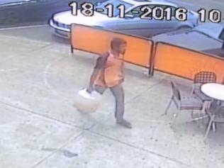 CCTV screen Grabs of a man walking towards the bank with a fuel container. A man allegedly set himself on fire at a Commonwealth Bank in Springvale.