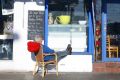 Costas Pavlou lounges in the sun outside his restaurant.