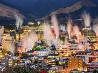 Beppu, Japan cityscape with hot spring bath houses with rising steam.