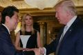 Japan PM Shinzo Abe and Donald Trump shake hands, as Ivaka Trump and her husband Jared Kushner watch.