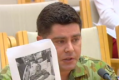 Former SAS trooper Evan Donaldson shows a Senate inquiry a photograph of his brother Andrew in a coma.