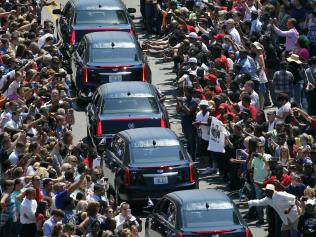 Muhammad Ali's funeral procession passes as onlookers line the street Friday, June 10, 2016, in Louisville, Ky. (AP Photo/Jeff Roberson)