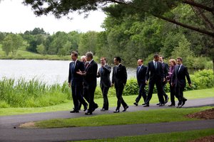 President Barack Obama talks with German Chancellor Angela Merkel and President Nicolas Sarkozy of France as as they walk with other G8 leaders to the family photo at the G8 Summit in Muskoka, Canada, June 25, 2010.  (Official White House Photo by Pete Souza)