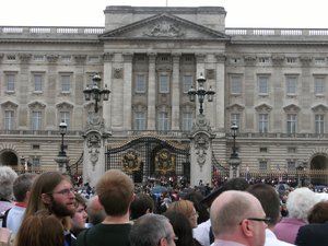 File - Tourists gather in front of Buckingham Palace, London, England.