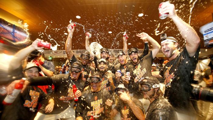 San Francisco Giants players celebrate in the clubhouse after clinching the second place wild card spot following their 7-1 win over the Los Angeles Dodgers in a baseball game in San Francisco, Sunday, Oct. 2, 2016. (AP Photo/Tony Avelar)