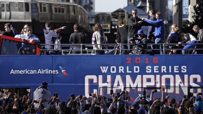 Chicago Cubs president of baseball operations Theo Epstein and general manager Jed Hoyer, right, point to each other as they acknowledge fans during a parade honoring the World Series champions, Friday, Nov. 4, 2016, in Chicago. (AP Photo/Kiichiro Sato)