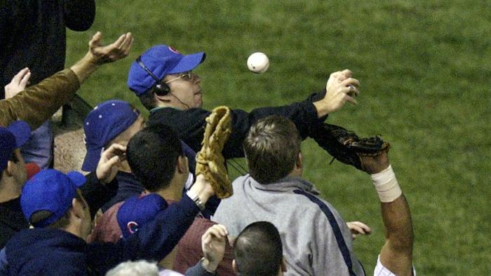 FILE - In this Oct 14, 2003, file photo, Steve Bartman catches a ball as Chicago Cubs left fielder Moises Alou's arm is seen reaching into the stands, at right, against the Florida Marlins in the eighth inning during Game 6 of the National League championship series Tuesday, Oct. 14, 2003, at Wrigley Field in Chicago. Bartman's spokesman, Frank Murtha, tells USA Today that Bartman is overjoyed by the Cubs first World Series title since 1908, but won't attend the victory parade in Chicago on Nov. 4, 2016. (AP Photo/Morry Gash, File)