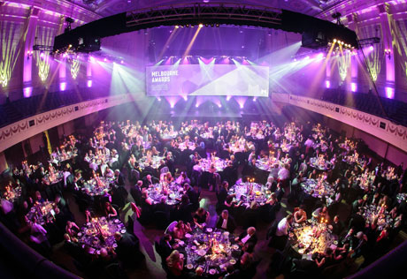 A large hall filled with tables of guests.