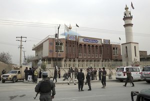 Afghan national police soldiers and civilian walk around the Shiite Baqir-ul Ulom mosque after a suicide attack inside it, in Kabul, Afghanistan, Monday, Nov. 21, 2016.