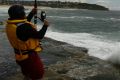 A man fishing off South Curl Curl rocks is wearing a life jacket as recommended by the NSW government.