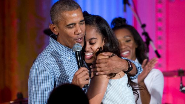 US President Barack Obama hugs and sings "Happy Birthday" to his daughter Malia during Independence Day celebrations in ...