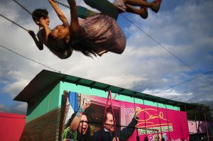 Children swing in a park next to an election billboard promoting Nicaragua's President Daniel Ortega and running mate, ...