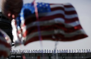 Sailors in lineup on board U.S. navy nuclear-powered aircraft carrier USS Ronald Reagan which arrives as some U.S. flag-shaped balloons are hoisted to welcome them at the U.S. Navy's Yokosuka base in Yokosuka,  south of Tokyo Thursday, Oct. 1, 2015. An American nuclear-powered aircraft carrier USS Ronald Reagan has entered its new home in Japan's Yokosuka naval port, replacing its predecessor USS George Washington. The arrival Thursday comes just as Tokyo tries to deepen defense ties with the US under new security law.(AP Photo/Eugene Hoshiko)