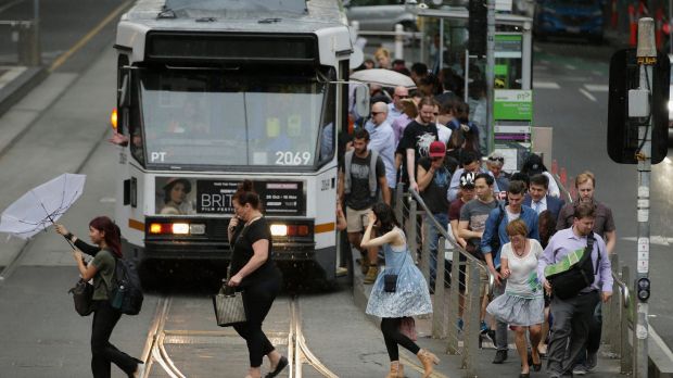 Commuters get off a tram in wild weather in Melbourne on Monday afternoon.