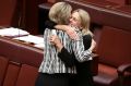 Senator Fiona Nash embraces Senator Michaelia Cash after the Fair Work (Registered Organisations) Amendment Bill 2014 ...