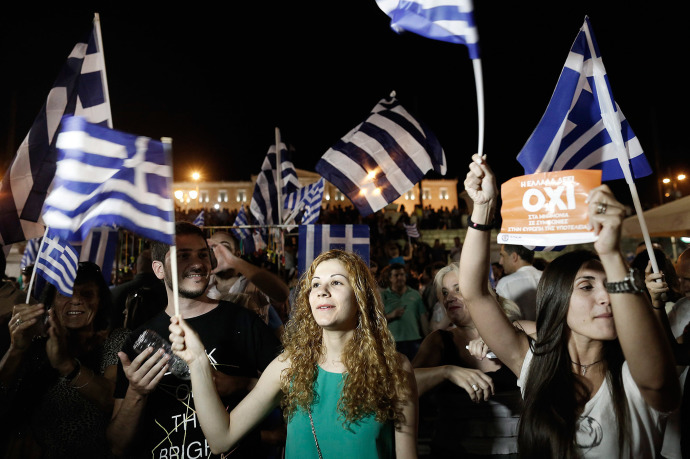 In Athens, supporters of the "No" campaign wave flags after the first results of the referendum. Yannis Kolesids / EPA