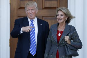 In this Nov. 19, 2016 file photo, President-elect Donald Trump and Betsy DeVos pose for photographs at Trump National Golf Club Bedminster clubhouse in Bedminster, N.J.