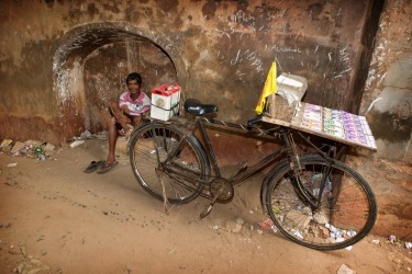 A street vendor in Negombo, Sri Lanka sells lottery tickets from his bicycle parked outside the entrance to the city's ...