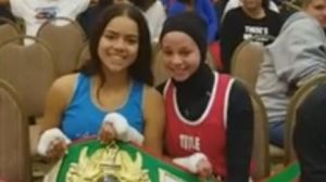 Aliyah Charbonier (L) presenting Amaiya Zafar (R) with the belt she was awarded after Zafar was disqualified from their ...