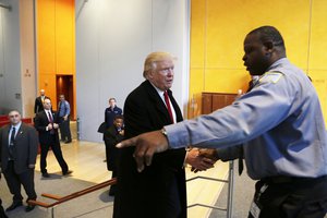 President-elect Donald Trump shakes hands with New York Times security guard Thomas Price as he leaves the building after a meeting with the newspaper, Tuesday, Nov. 22, 2016, in New York.