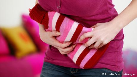 woman holding a hot water bottle to her stomach