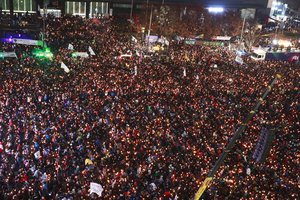 Protesters gather with candles during a rally against South Korean President Park Geun-hye on a main street in Seoul, Saturday, Nov. 26, 2016.