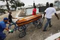 Leonardo Martins da Silva helps move the casket during the burial of his son Leonardo.