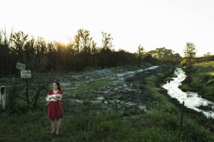 Samantha Kelly holds her baby William beside one of the drains running from the Williamtown RAAF base near Newcastle.