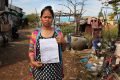 Cambodian surrogate mother Hour Vanny, holding the two-page document she signed with Fertility Solutions, operated by ...