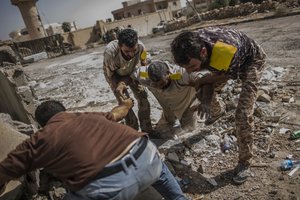 A fighter of the Libyan forces affiliated to the Tripoli government is helped by comrades after being shot by a Sniper, in Sirte, Libya, Sunday, Oct. 2, 2016.