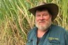 Gordon Oakes stands in a cane field.