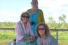 women in front of a dam with art materials