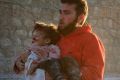 Pulled from the wreckage: A man carries a Syrian child to safety following airstrikes on residential areas of Aleppo, ...