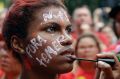 A demonstrator with the Portuguese words "Temer out" holds has her make-up applied during a protest demanding the ...
