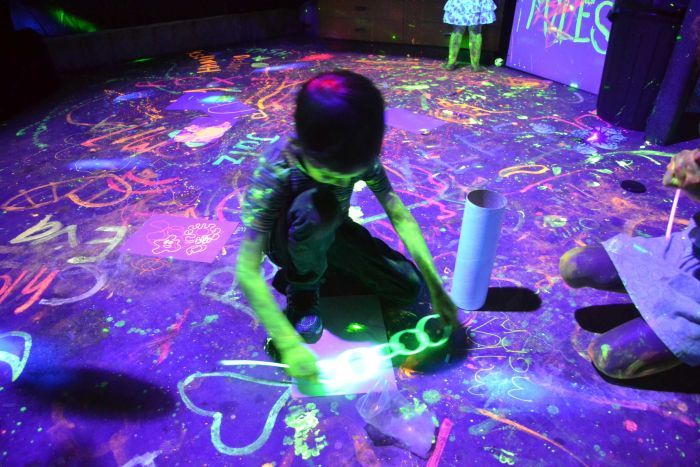 Myles Scharf plays with glow sticks at a party