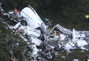 Rescue workers stand at the wreckage site of a chartered airplane that crashed outside Medellin, Colombia, Tuesday, Nov. 29, 2016.