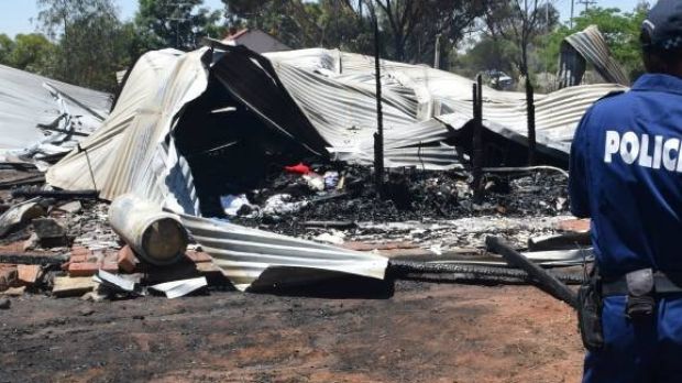 Police and fire investigation officers analyse the remains of the home.