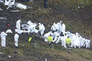 Rescue workers arrange the bodies of victims of an airplane that crashed in La Union, a mountainous area outside Medellin, Colombia, Tuesday , Nov. 29, 2016.