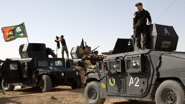 Iraqi special forces soldiers - flying a sectarian Shiite flag from their vehicles - move out to join the Mosul ...