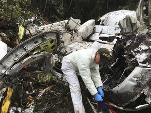 A police officer works at the wreckage site of a chartered airplane that crashed in La Union, a mountainous area outside Medellin, Colombia, Tuesday, Nov. 29, 2016.