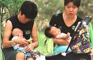 Two mothers hold their babies in a Beijing park Sunday, Sept. 1, 2002, as China's first family planning law takes effect.