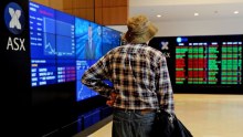 An elderly man watches the share market prices at the Australian Stock Exchange