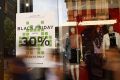 Pedestrians walk past a Black Friday sale advertisement in Sydney. 