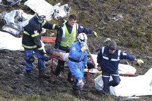 Rescue workers recover a body from the wreckage site of an airplane crash, in La Union, a mountainous area near Medellin, Colombia, Tuesday, Nov. 29, 2016.