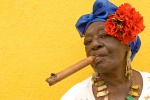 A Cuban woman, in traditional colonial costume, with a famous Cuban cigar in Old Havana.