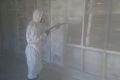 A cleaner decontaminating a garage with chemical foam.