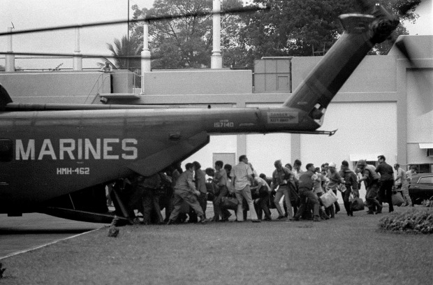 US military and civilian personnel rush to board a Marines helicopter during the evacuation of the US Embassy in Saigon ...