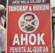 A man holds a poster during a rally against Jakarta's minority Christian Governor Basuki "Ahok" Tjahaja Purnama.