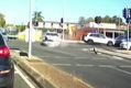 Dashcam captures the moment a driver crashes into a police car at an intersection in Stafford, Queensland on Friday morning.